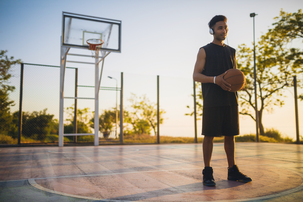 Pessoa em uma quadra de basquete com uma bola de basquete nas mãos