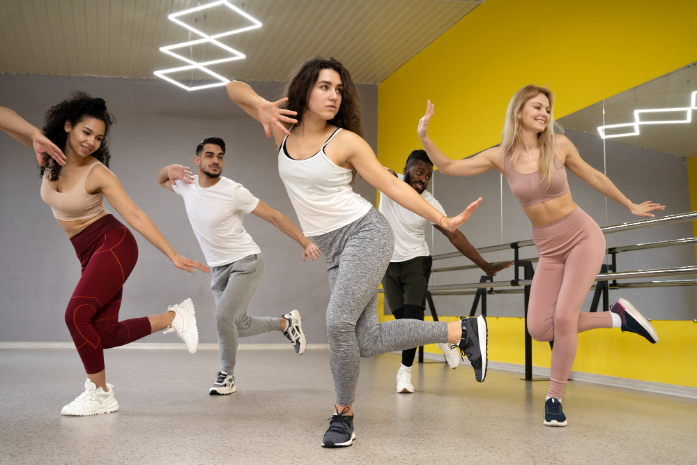 Grupo de cinco pessoas fazendo uma aula de dança